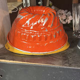 Assorted glassware with burgundy wine glass, red candle, and orange ridged baking mold - thumbnail 1 of 8