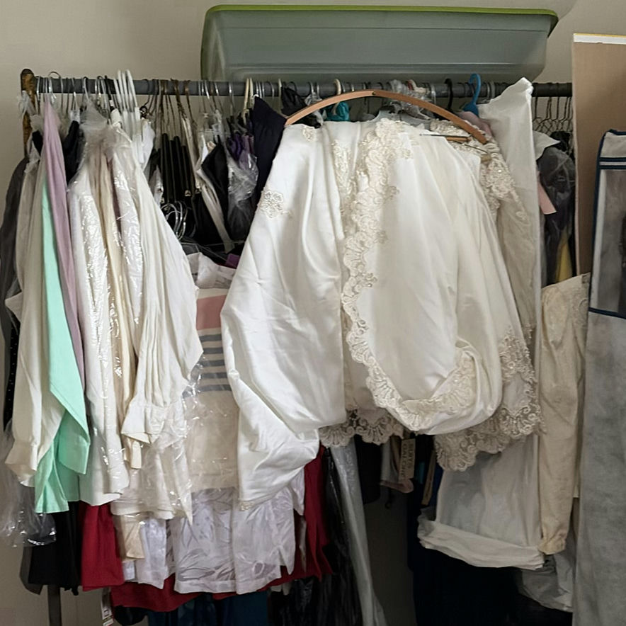 White bridal gowns and formal wear on hangers - image 1 of 4