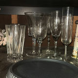 Assorted glassware with burgundy wine glass, red candle, and orange ridged baking mold - thumbnail 2 of 8