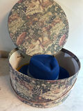 Round tapestry hatbox with blue and yellow hats - thumbnail 1 of 4