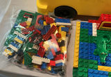 A yellow plastic school bus loaded with a bag of assorted colorful legos. - thumbnail 3 of 6