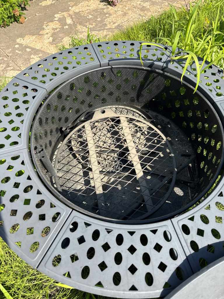 Round gray metal firepit with perforated edge and inner grate - image 3 of 3