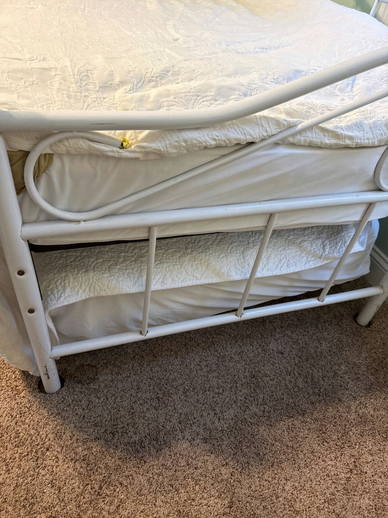 White metal trundle  bed frame with upholstered headboard, white quilt, and floral-pattern mattress - image 3 of 5