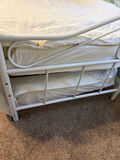 White metal trundle bed frame with upholstered headboard, white quilt, and floral-pattern mattress - thumbnail 3 of 5