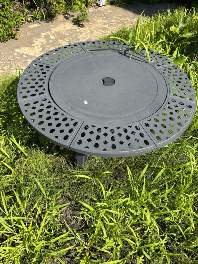 Round gray metal firepit with perforated edge and inner grate - image 1 of 3
