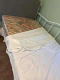White metal trundle  bed frame with upholstered headboard, white quilt, and floral-pattern mattress - thumbnail 4 of 5