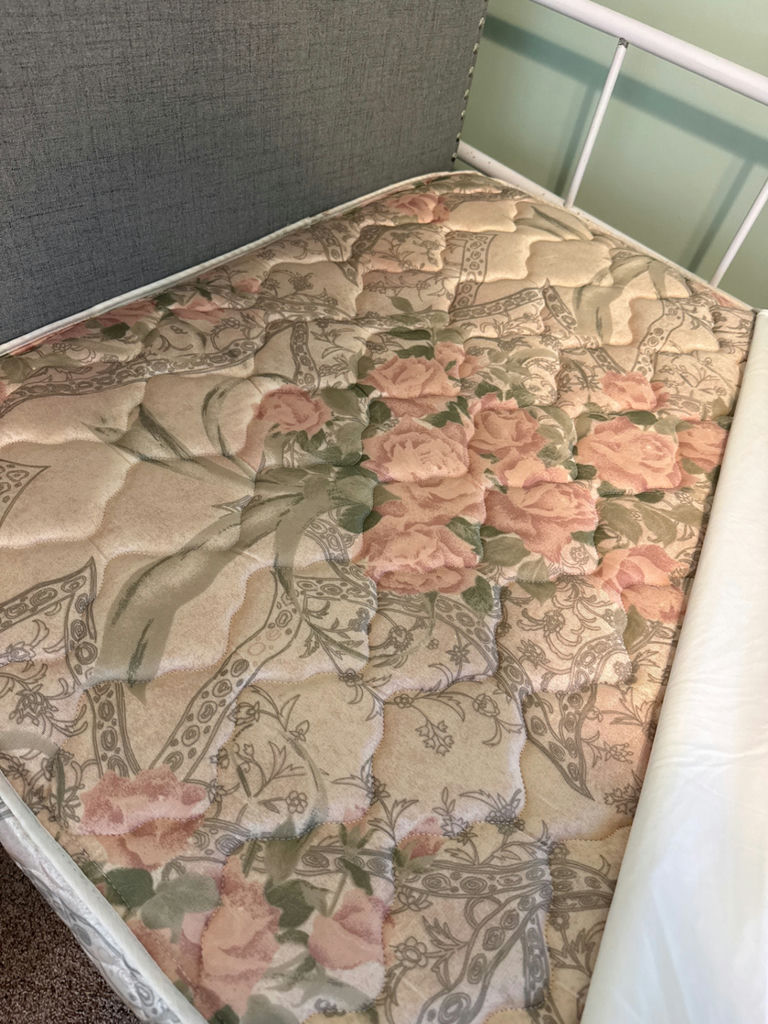 White metal trundle bed frame with upholstered headboard, white quilt, and floral-pattern mattress - image 5 of 5
