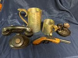 Antique hammered metal pitchers, a vintage black telephone device, and a wooden-stock pistol - thumbnail 2 of 4