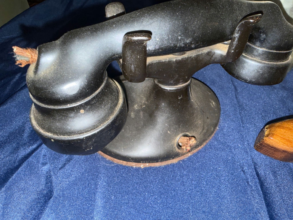 Antique hammered metal pitchers, a vintage black telephone device, and a wooden-stock pistol - image 3 of 4