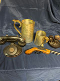 Antique hammered metal pitchers, a vintage black telephone device, and a wooden-stock pistol - thumbnail 1 of 4