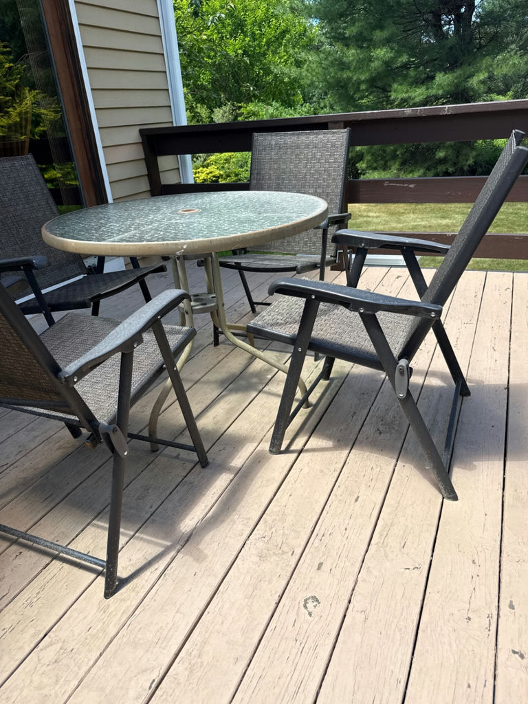 Round glass-top patio table with four metal chairs - image 2 of 3