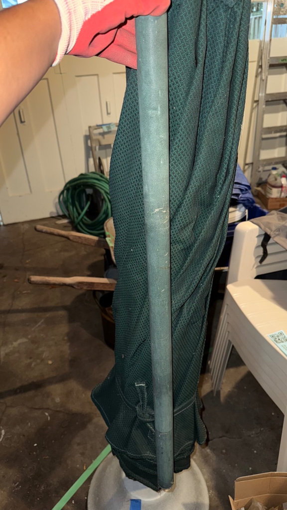 Folded green patterned outdoor umbrella with base - image 3 of 5