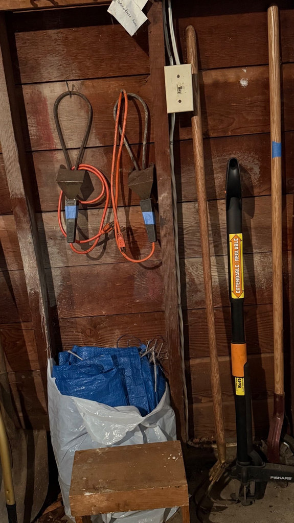 Garage tool collection with shovels, cords, and tarps - image 1 of 6