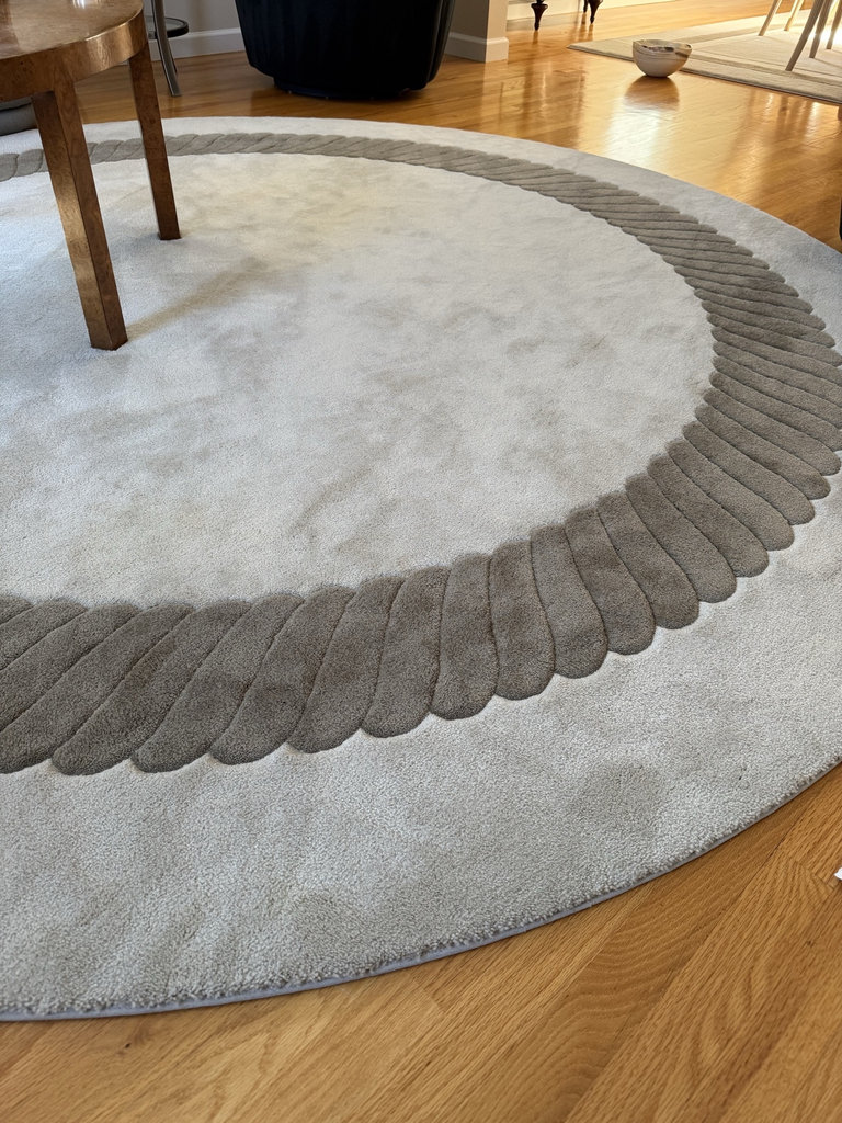 Round taupe rug with decorative border  - image 1 of 4
