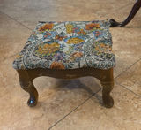 Round glass-top pedestal table with carved wooden base and floral upholstered ottoman - thumbnail 5 of 6