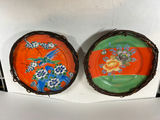 Pair of hand-painted porcelain plates with floral and bird designs in wicker frames - thumbnail 1 of 5