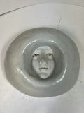 Circular ceramic bowl with carved interior face relief - thumbnail 1 of 3