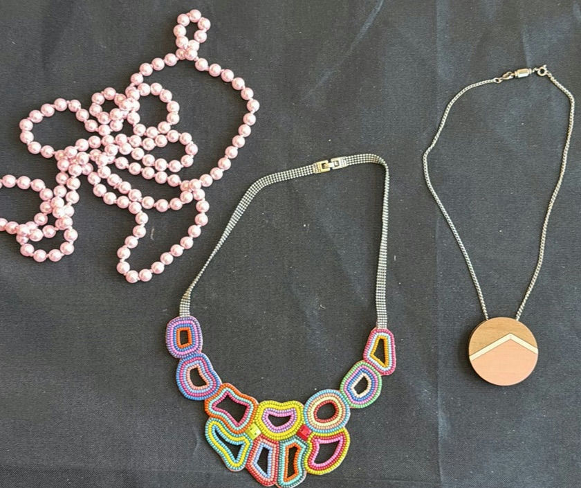 Assorted necklaces: pink pearl strand, colorful beaded necklace, and wood pendant necklace - image 5 of 5