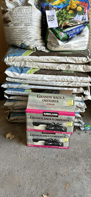 Stacked garden soil bags and garbage bags - Image 1 of 4