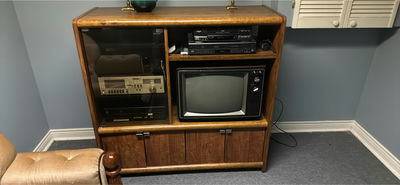 Vintage wooden media cabinet with CRT TV, blue upholstered recliner, end table, and landscape painting - Image 1 of 7
