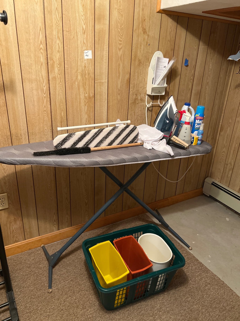 Ironing board setup with iron, cleaning supplies, and plastic storage bins - image 3 of 6