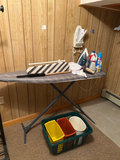Ironing board setup with iron, cleaning supplies, and plastic storage bins - thumbnail 3 of 6