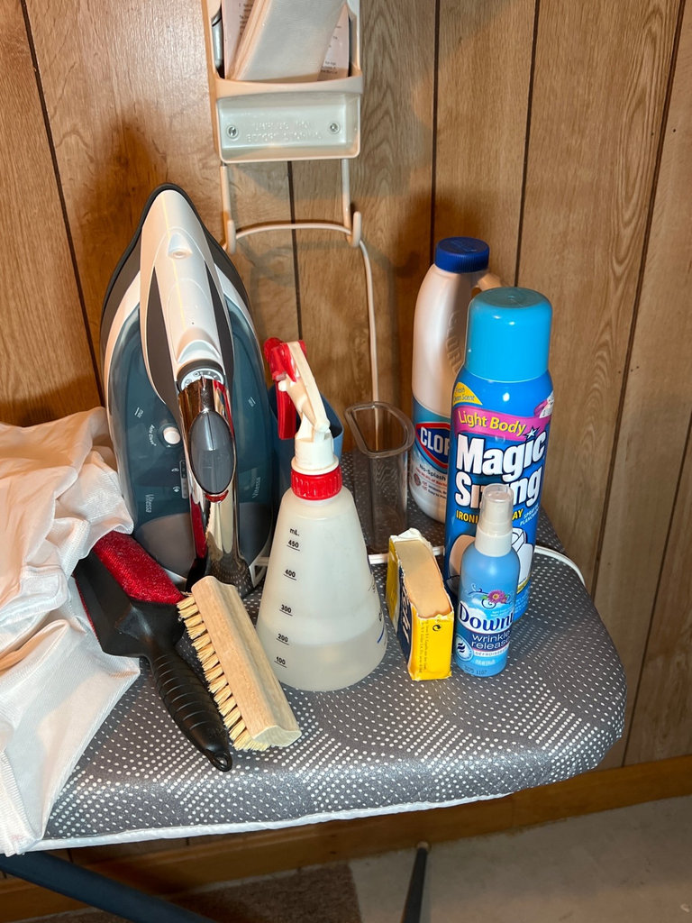Ironing board setup with iron, cleaning supplies, and plastic storage bins - image 5 of 6