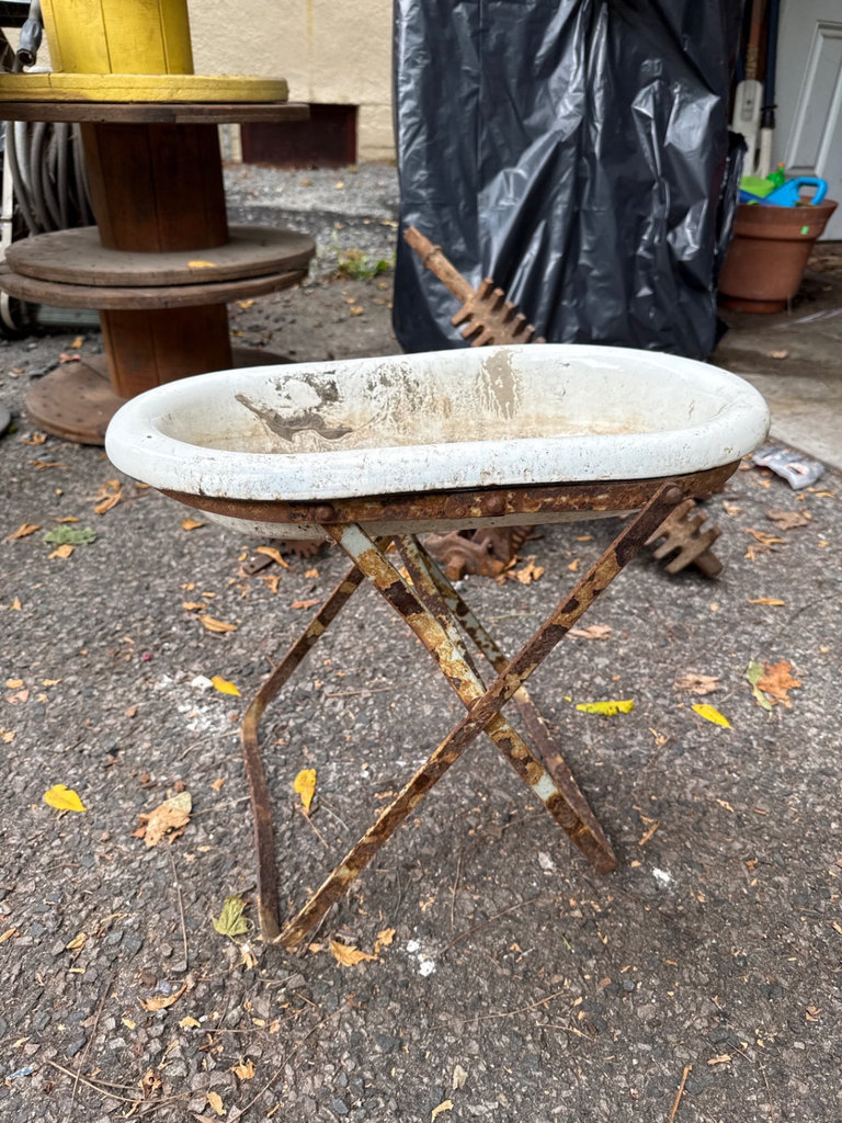 Weathered enamel infant tub basin on rusted folding stand - image 1 of 9