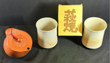 Yixing-style brown teapot with two cups and yellow box - thumbnail 1 of 4
