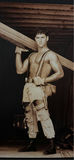 Man in distressed workwear with suspenders carrying a wooden beam - thumbnail 3 of 3