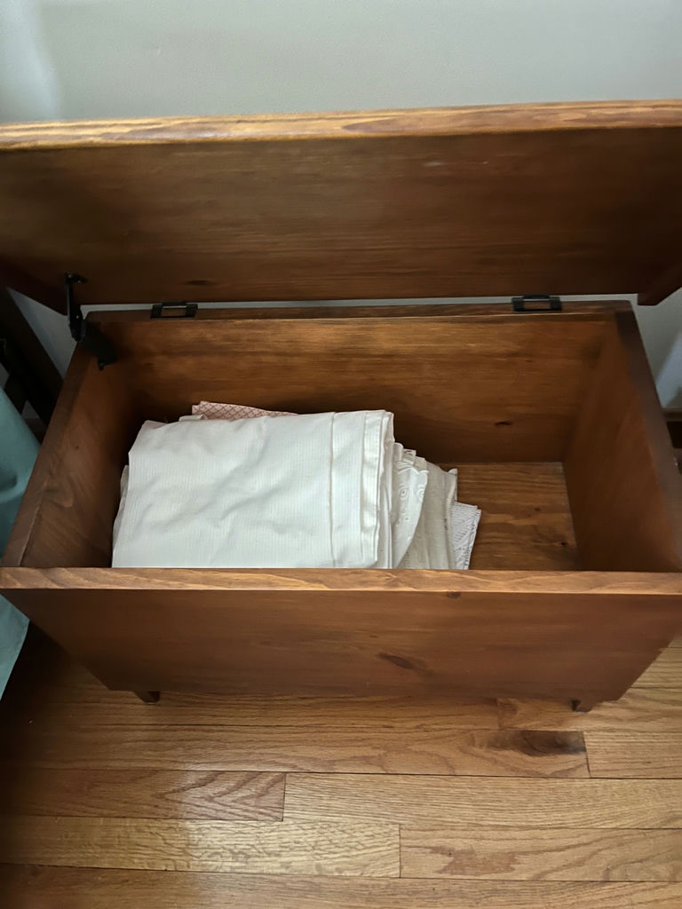 Wooden storage chest with folded linens - image 2 of 2