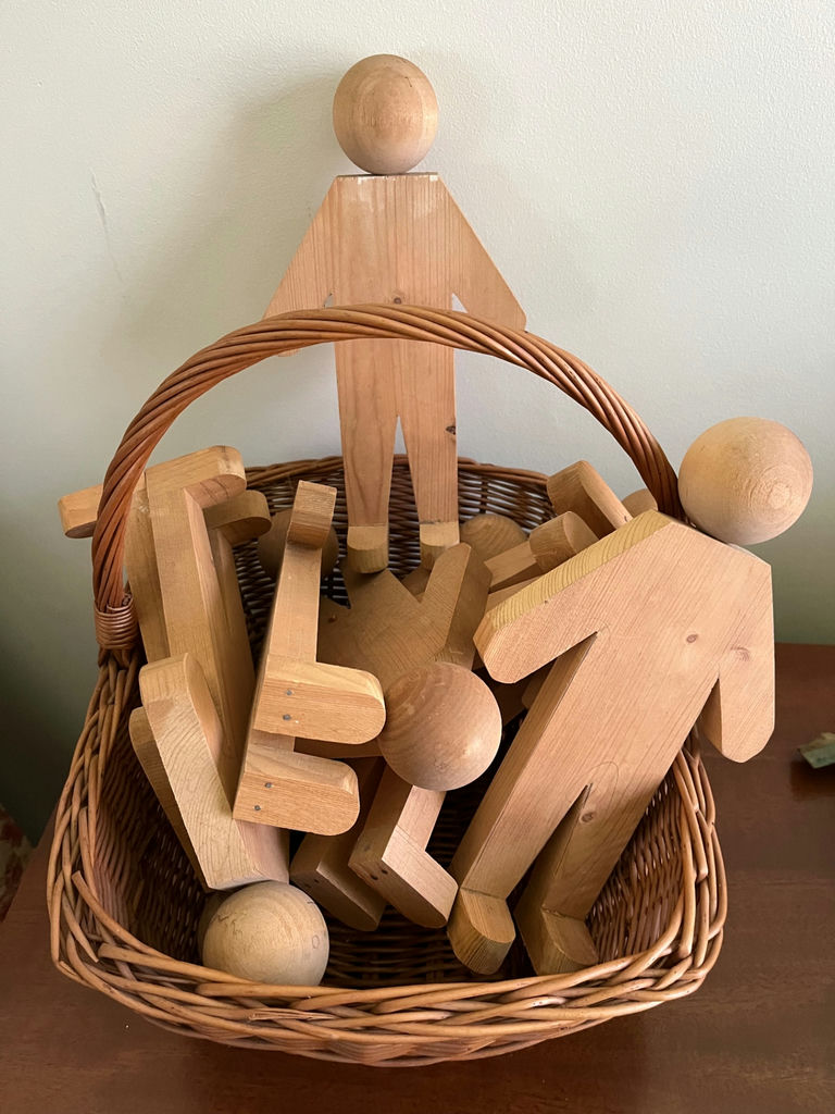 Wooden humanoid figures  in wicker basket - image 1 of 1