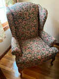 Floral patterned wingback armchair and small oval footstool - thumbnail 1 of 3