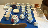 Assorted Ceramic Mugs, Teapots, and Saucers - thumbnail 1 of 7