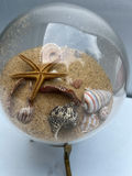 Glass globe sand display with seashells and starfish on brass stand - thumbnail 2 of 4