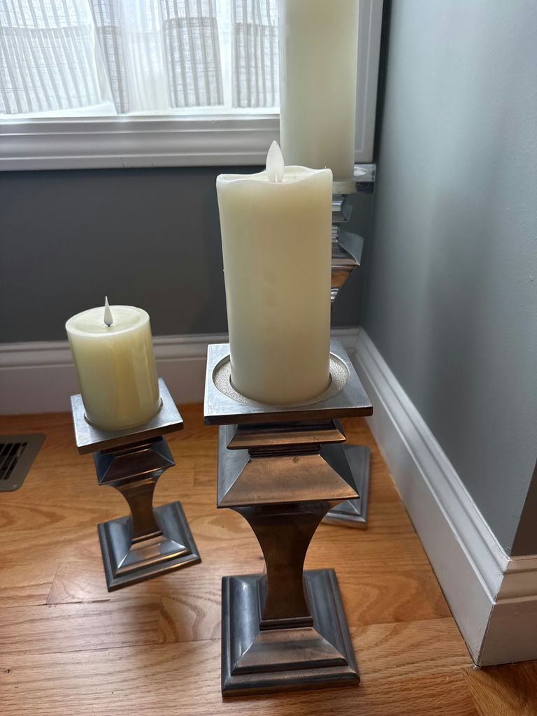 Set of three metal pillar candle holders with candles - image 1 of 2