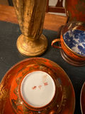 Orange-red porcelain teacups with blue interiors, matching saucers and plate, plus a gold vase - thumbnail 3 of 4