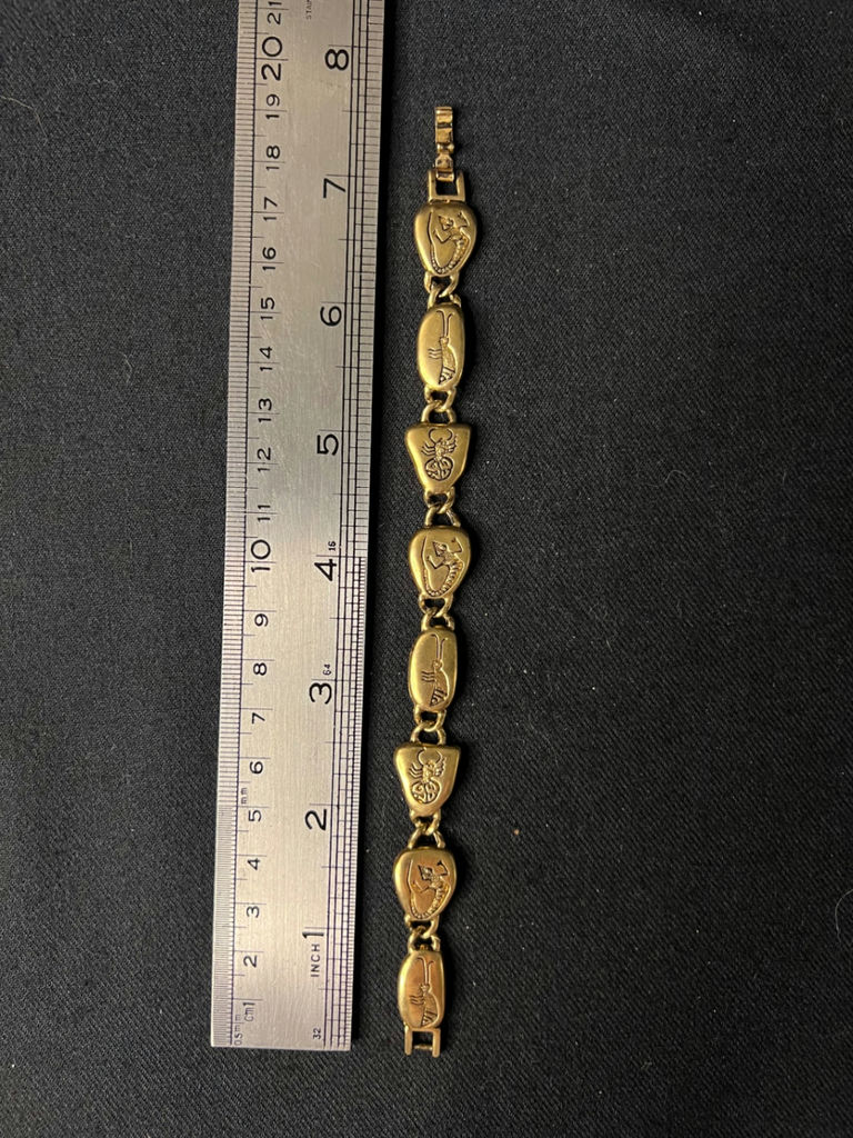 Gold-tone bracelet with engraved shield links, beaded hoop earrings, and a wire bow ornament - image 4 of 10