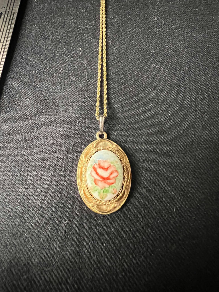 Gold-tone cameo pendant necklace with floral center, purple chip earrings, and two-tone circular earrings - image 4 of 11