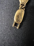 Gold-tone bracelet with engraved shield links, beaded hoop earrings, and a wire bow ornament - thumbnail 8 of 10
