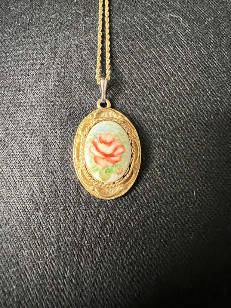 Gold-tone cameo pendant necklace with floral center, purple chip earrings, and two-tone circular earrings - image 1 of 11