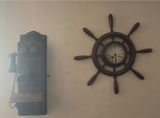 Vintage wall-mounted ship wheel clock, antique telephone, and wooden wall rack - thumbnail 1 of 8