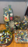 Assorted glass marbles in jars, bowls, and bottles - thumbnail 1 of 5