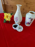 Floral porcelain vases, a small lidded container, and a yellow artificial daffodil - thumbnail 1 of 2