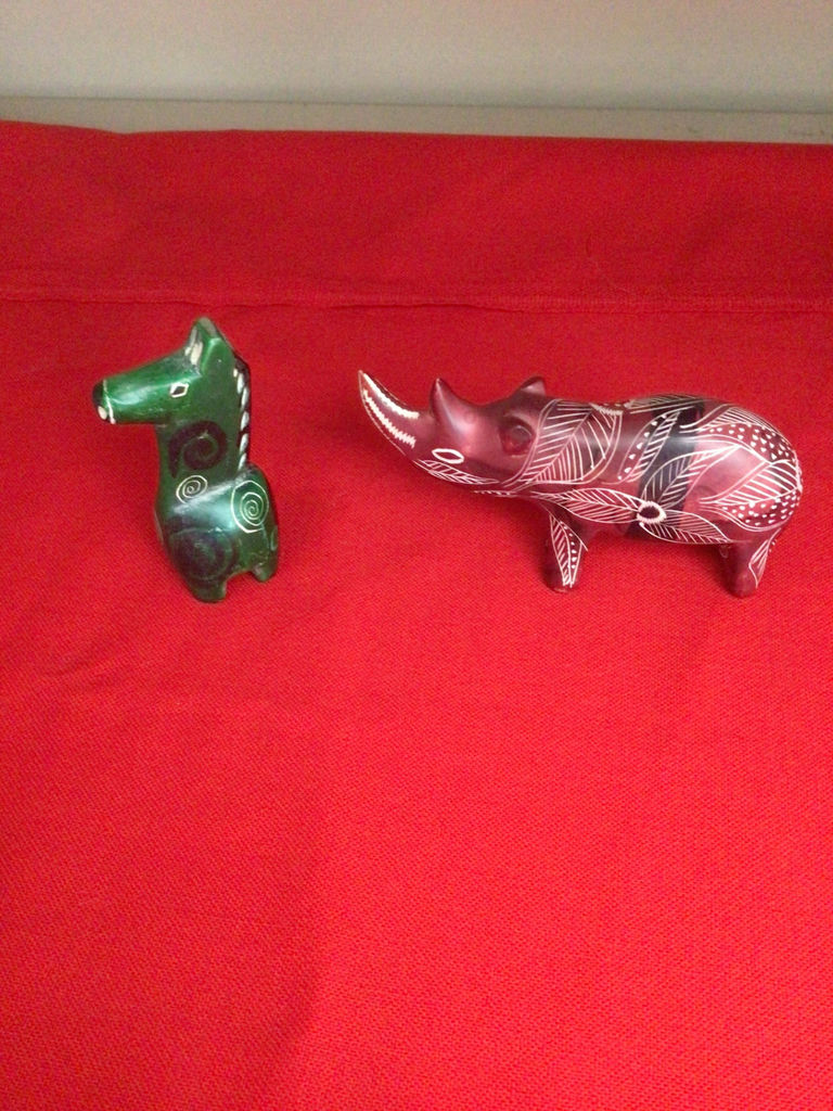Green carved canine figurine and red leaf-patterned boar figurine - image 1 of 2