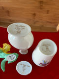 Floral porcelain vases, a small lidded container, and a yellow artificial daffodil - thumbnail 2 of 2