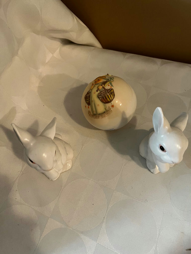 Two white ceramic bunny figurines with a decorative painted ball - image 1 of 1