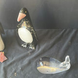 Assorted decorative items including penguin figurines, an ornate tin, a jewelry box with knotted bracelets, a glass sculpture, and round coasters - thumbnail 6 of 8