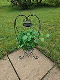 Heart-shaped wrought iron plant stand with a potted faux green plant and a Welcome sign - thumbnail 1 of 3