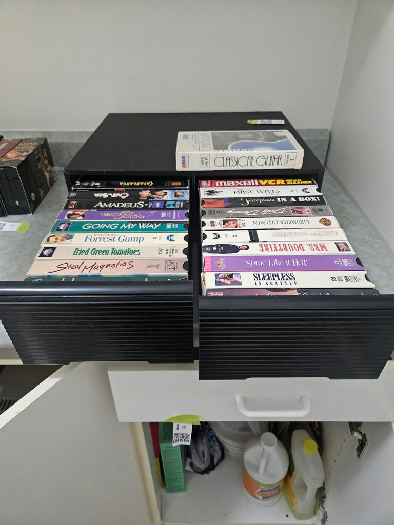 VHS tapes in a black storage cabinet with a Classical Guitar video box - image 1 of 6